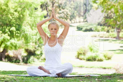 Woman sitting in a yoga position outdoors