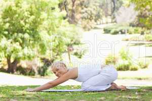 Side view of a woman doing stretches on the lawn