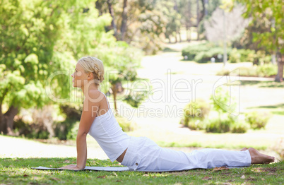 Side view of a woman doing stretches on the grass
