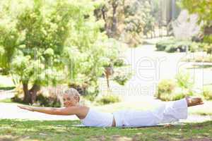 Side view of a smiling woman doing her exercises in the park