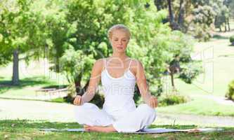 Woman sitting on the meadow in yoga position