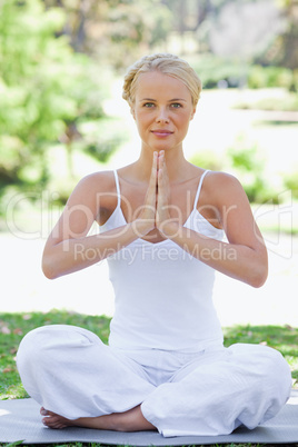 Relaxed woman on the lawn in a yoga position