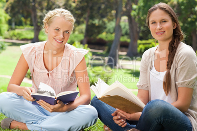 Students sitting in the park with their books
