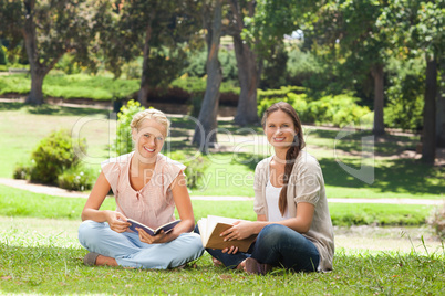 Friends sitting with their books in the park