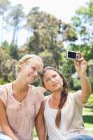 Woman taking a picture of herself and a friend