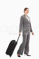 Smiling businesswoman with suitcase walking