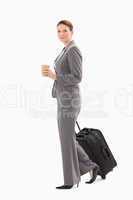 Businesswoman walking with coffee and suitcase