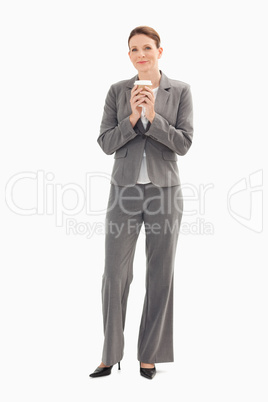 Businesswoman holding cup of coffee with both hands