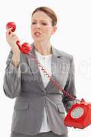 Angry businesswoman shouts at phone