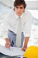 Businessman with construction drawings and a hard hat