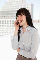 Woman laughing on her phone in the office