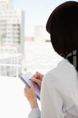 A woman begins to write down on her notepad