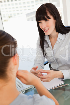 The smiling business lady chats with a fellow employee