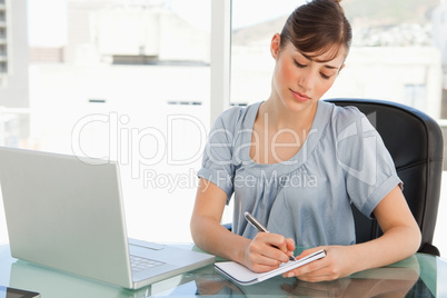 A woman takes down notes on her notepad