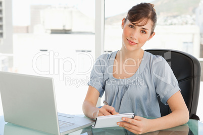 A smiling business woman looks at the camera