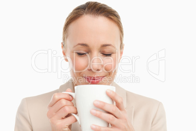 Woman in a suit smelling her tea