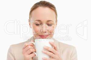 Woman in a suit smelling her tea