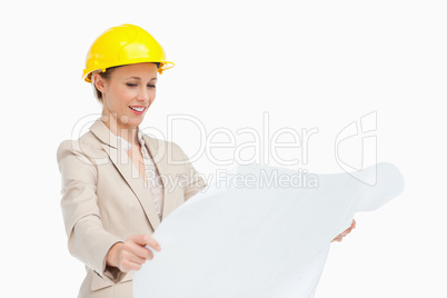 Smiling woman in a suit looking plans