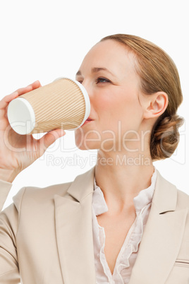 Businesswoman in a suit drinking a takeaway coffee