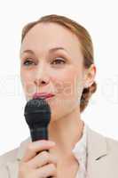 Woman in a suit speaking with a microphone