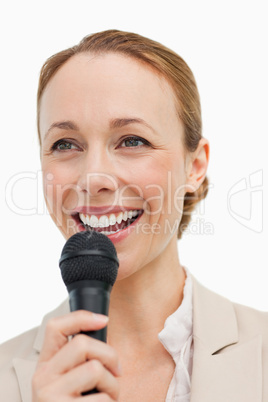 Enthusiastic woman in a suit speaking with a microphone