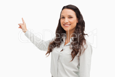 Portrait of a happy brunette pointing in her back