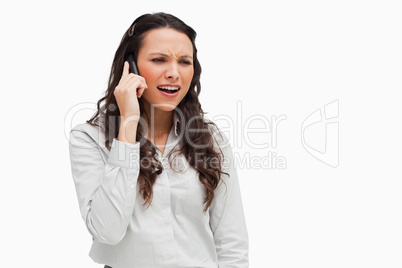 Close-up of a brunette grimacing on the phone