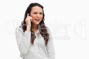 Close-up of a brunette grimacing on the phone