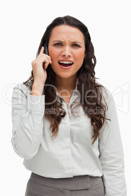 Close-up of a brunette grimacing while calling