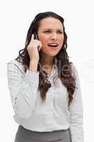 Close-up of a businesswoman grimacing while phoning