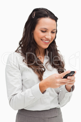 Brunette smiling while looking her text message