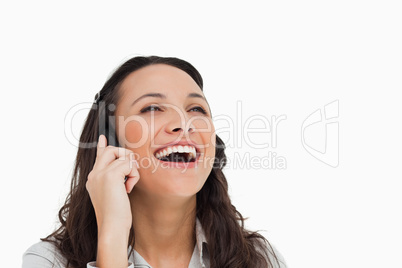 Brunette laughing while making a call