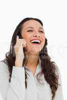 Pretty brunette laughing while phoning