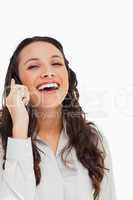 Portrait of a pretty brunette laughing while phoning