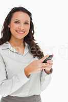 Portrait of a brunette smiling while using her mobile