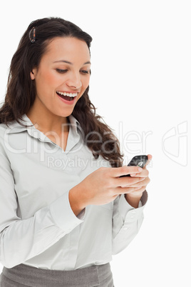 Brunette beaming while using her mobile
