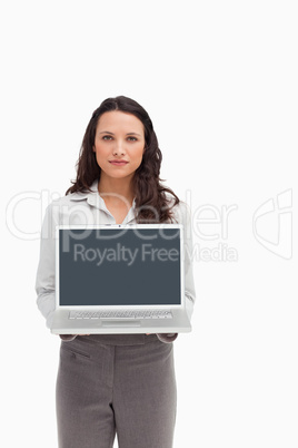 Brunette standing while showing a laptop screen