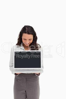 Woman standing while showing a laptop screen