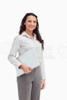 Brunette standing while holding a laptop