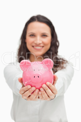 Brunette showing a piggy bank