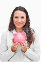 Brunette holding a piggy bank