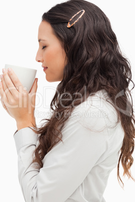 Profile of a brunette smelling a hot coffee