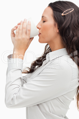 Profile of a brunette drinking a hot coffee