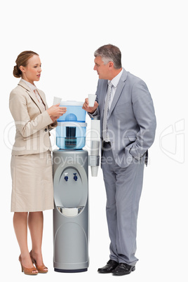 People in suit talking next to the water dispenser