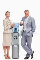Portrait of business people smiling next to the water dispenser