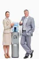 Portrait of smiling business people next to the water dispenser