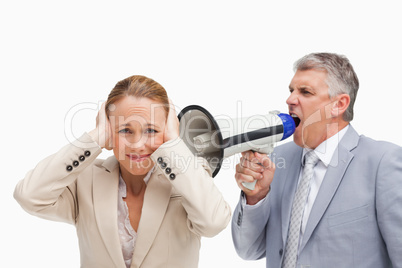 Businessman yelling with a megaphone after his colleague