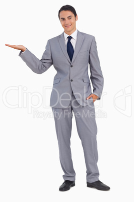 Smiling man in suit presenting with the hand