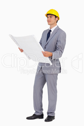 Good-looking man in a suit with safety helmet and plans