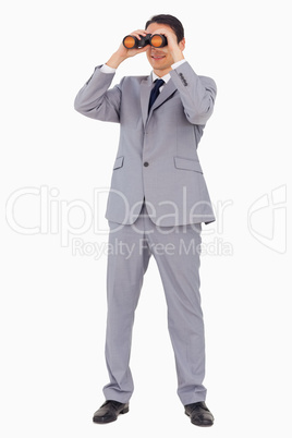 Businessman smiling while using binoculars